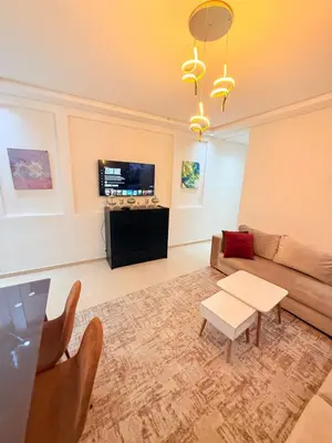 a living room with a couch and a tv at Appartement Tachfine lumineux FAMILY in Marrakech