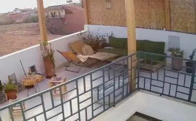 a balcony with a couch and tables and chairs at Riad rooftop, pool and stunning view in Marrakech
