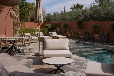 a patio with chairs and tables and a pool at Villa luxe Dar Paumar, Marrakech in Marrakech