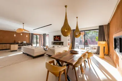 a living room with a wooden table and chairs at Villa luxe Dar Paumar, Marrakech in Marrakech