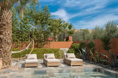 a patio with two chairs and a hammock at Villa luxe Dar Paumar, Marrakech in Marrakech