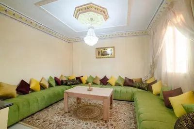 a living room with a green couch and a table at Family Apartment in Marrakech 3 Bedrooms & Balcony with View in Marrakech