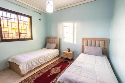 two beds in a room with two windows at Family Apartment in Marrakech 3 Bedrooms & Balcony with View in Marrakech