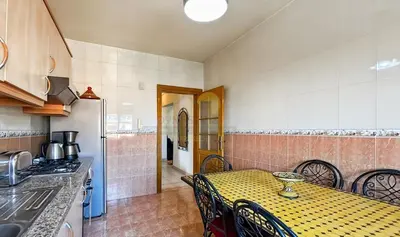 a kitchen with a yellow table and chairs and a refrigerator at Appartement charmant à Guéliz in Marrakech