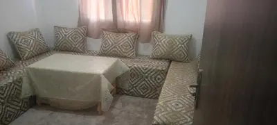 a room with a couch with a table and pillows at المغرب in Marrakech