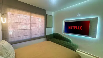 a bedroom with a bed and a tv on the wall at Appartement PRESTIGIA MARRAKECH VILLAGE in Marrakech