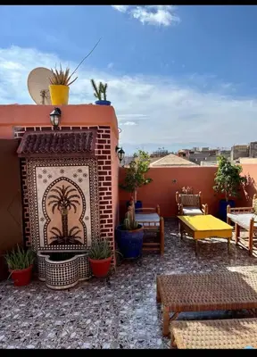 an outdoor patio with a fireplace on a roof at Terrace Room with Atlas View in Marrakech