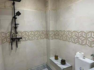 a bathroom with a shower with a toilet and a shower at Joli appartement proche aéroport in Marrakech