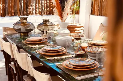 a table with plates and glasses on top of it at Riad de charme Aïtana au cœur de la Médina in Marrakech
