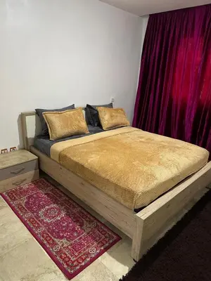 a bed in a bedroom with a red curtain at Le Central Hivernage 8-37-44 face gare CTM et a 10mn de l'aéroport in Marrakech