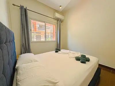 a bedroom with two beds and a window at Élégant Appartement 2 Chambres avec Piscine et Climatisation à Guéliz in Marrakech