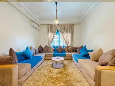 a living room with blue couches and a table at Élégant Appartement 2 Chambres avec Piscine et Climatisation à Guéliz in Marrakech