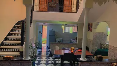 a living room with a staircase and a table at Raid Mariama in Marrakech