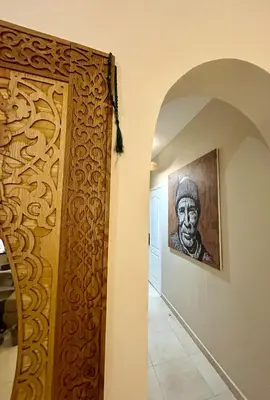 a painting of a man on a wall next to a hallway at Dar Mimouna - Authenticité & Confort Moderne in Marrakech