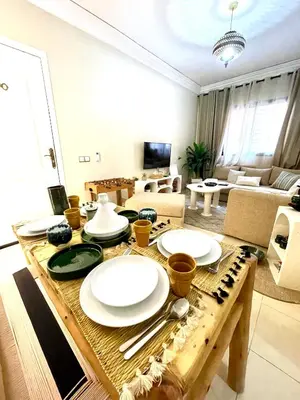 a living room with a table with plates on it at Dar Mimouna - Authenticité & Confort Moderne in Marrakech