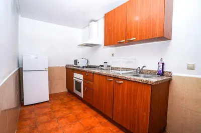 a kitchen with wooden cabinets and a white refrigerator at Majorelle Apartment 1- Bedroom 1-Terrace Centre in Marrakech