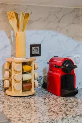 a kitchen counter with a red toaster and some breadsticks at 1BR Appart 2 min de M Avenue , Pool , Balcony & Parking & 24h j7 security in Marrakech