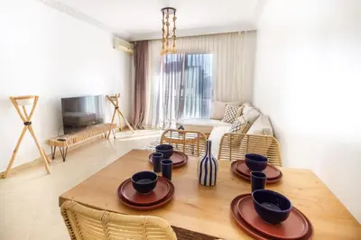 a living room with a wooden table and chairs at La Menara - 2 Chambres - Centre - Wifi in Marrakech