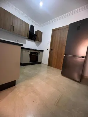 a kitchen with a stainless steel refrigerator and wooden cabinets at Cozy Apartment With Pool 5 min from Guéliz in Marrakech