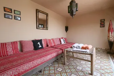 a living room with a red couch and a table at Riad XCIX, basin, 3 bedrooms in Medina excluded in Marrakech