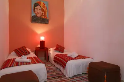 a room with two beds and a painting on the wall at Riad XCIX, basin, 3 bedrooms in Medina excluded in Marrakech