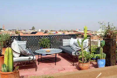a patio with couches and a table and potted plants at Riad XCIX, basin, 3 bedrooms in Medina excluded in Marrakech