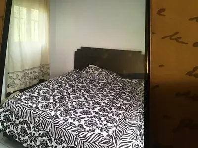 a bed with a black and white comforter in a bedroom at Marrakech village touristique in Marrakech