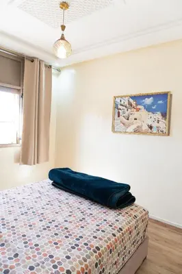 a bedroom with a bed with a blue pillow on it at Appartement de luxe, à 2min de Guéliz in Marrakech