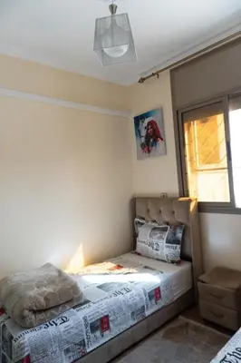 a bedroom with a bed and a window at Appartement de luxe, à 2min de Guéliz in Marrakech