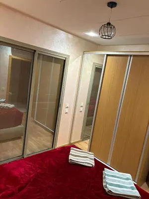 a room with mirrors and a red bed with towels at Gemütliche Wohnung in Marakesch in Marrakech