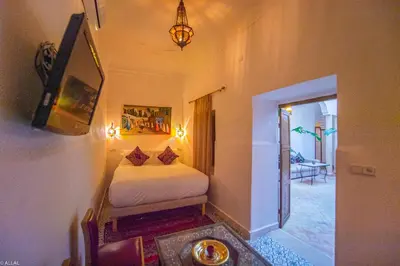 a bedroom with a bed and a television in a room at Riad Amskal in Marrakech