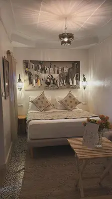 a bedroom with a large bed and a table at Riad Amskal in Marrakech