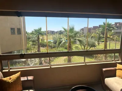 a window in a room with a view of palm trees at Prestigia residences in Marrakech