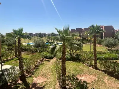 a row of palm trees in a park at Prestigia residences in Marrakech