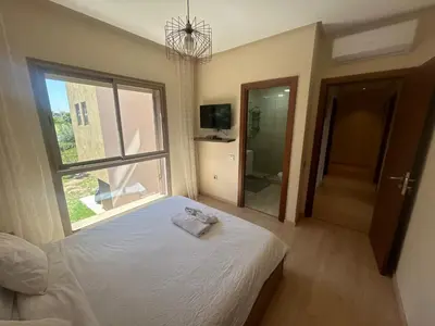 a bedroom with a bed and a large window at Prestigia residences in Marrakech