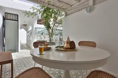 a dining room with a white table and chairs at DeaRiad, Medina, Basin, 2 Bedrooms in Marrakech