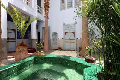 an indoor pool in a courtyard with palm trees at Riad La Tulipe, private, 4 Ch, medina in Marrakech
