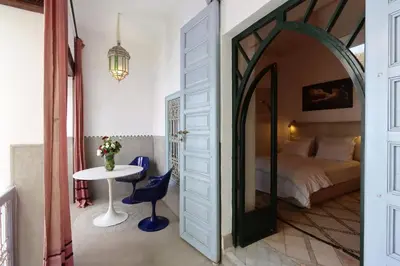 a bedroom with a bed and a table and a mirror at Riad La Tulipe, private, 4 Ch, medina in Marrakech