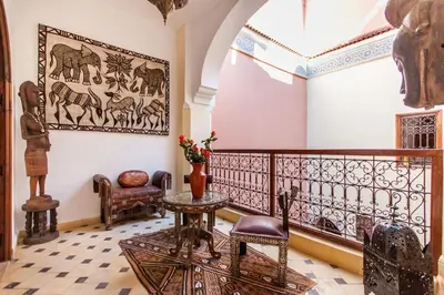 a room with a balcony with a table and chairs at Dar Jena, Rare Riad in Medina on Mamounia in Marrakech