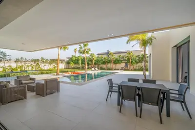 an indoor patio with tables and chairs and a swimming pool at Villa Alia - Piscine Chauffée - 4 BR BA - Wifi - Parking in Marrakech