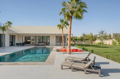 a villa with a swimming pool and palm trees at Villa Alia - Piscine Chauffée - 4 BR BA - Wifi - Parking in Marrakech