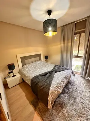 a bedroom with a bed and a large window at Appartement familiale 2 chambres Prestigia in Marrakech