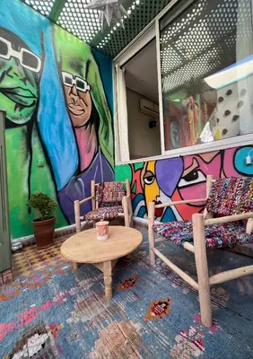a room with a mural with two beds and a table at Riad dar lfen in Marrakech