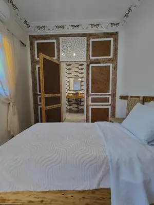 a bedroom with a bed and a room with a window at Dar Manzakin in Marrakech