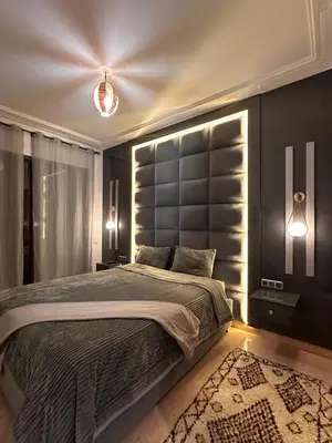 a bedroom with a large bed with a large headboard at Marrakech Oasis, Residence Ennaim in Marrakech