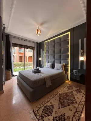 a bedroom with a large bed and a large window at Marrakech Oasis, Residence Ennaim in Marrakech