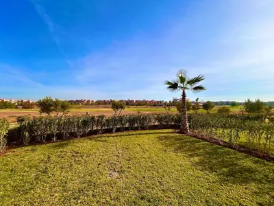 a palm tree in the middle of a field at Appartement RDJ - Golf - Piscine - restaurants in Marrakech