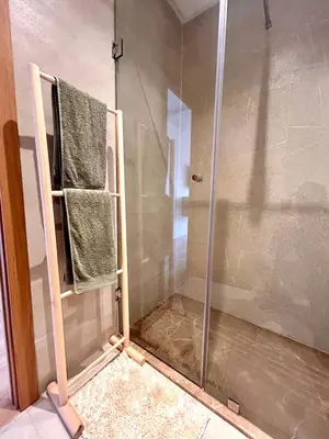 a shower with a glass door and two towels at Appartement RDJ - Golf - Piscine - restaurants in Marrakech