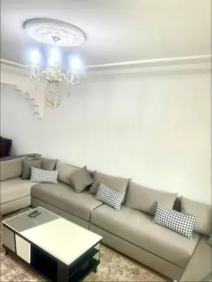 a living room with a couch and a chandelier at Charming Two-Bedroom Apartment in Gueliz,Marrakesh in Marrakech