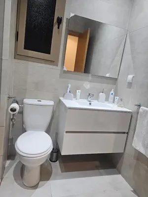 a bathroom with a white toilet and a sink at Prestigia Luxury Golf-View Escape in Marrakech